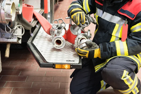 Bombero en acción conectar una manguera de agua — Foto de Stock