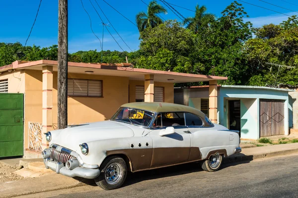 Trinidad, CUBA - 03 DE JUNIO DE 2015: Coche clásico americano estacionado bajo el cielo azul ante una casa — Foto de Stock