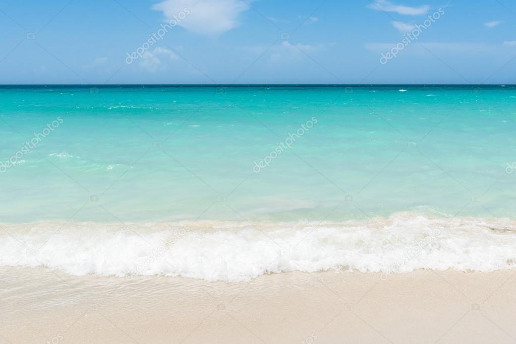 Foam waves on the caribbean beach with horizon view