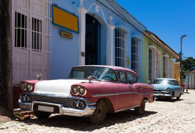 Trinidad, Küba - 30 Haziran 2014: Küba Trinidad park edilmiş bir bina önce'deki Amerikan vintage arabalar