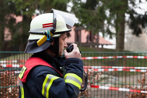 Vigile del fuoco con un raido mobile in mano — Foto Stock