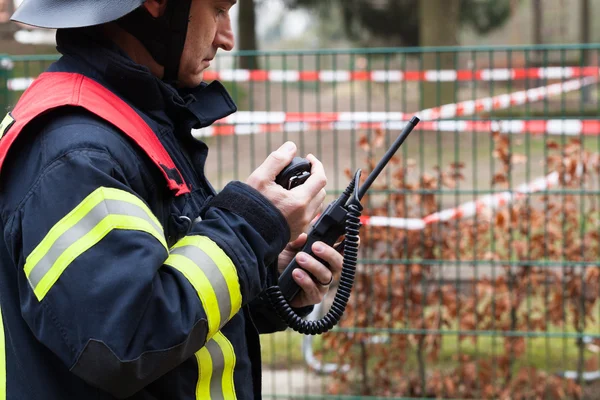 Feuerwehrmann mit Mobiltelefon in der Hand — Stockfoto