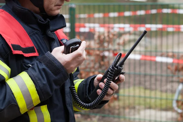 İtfaiyeci elinde bir telefon raido ile