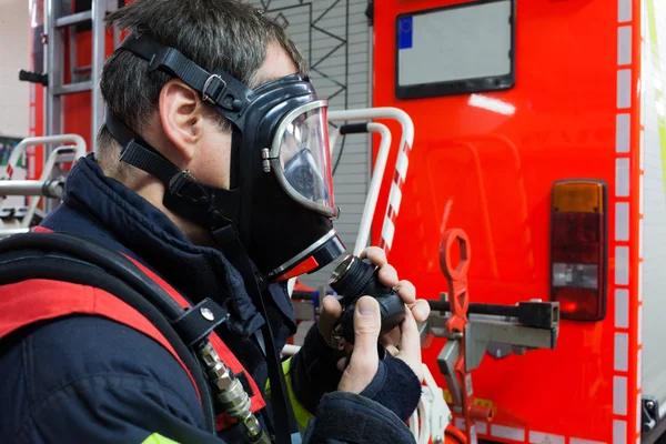 Brandweerman met beschermend masker in actie — Stockfoto