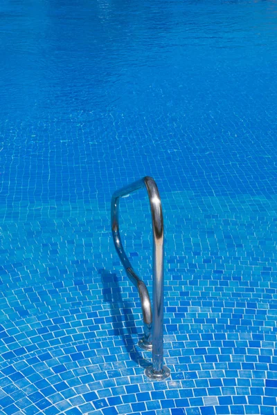 Vista para piscina com água azul e corrimão — Fotografia de Stock