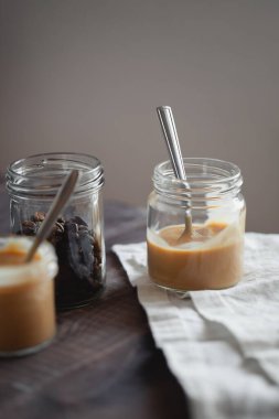 Kahve aromalı yoğurt tatlısı ahşap masada cam kavanozda. Sağlıklı yaşam tarzı, süper yiyecekler.