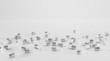 Boş beyaz ve gümüş kapsülü arka plandaki parlak toz haplarının üzerine aç. Sağlık, tıbbi ilaç, covid-19 aşısı, besin takviyesi, kozmetik vitaminler, tablet.