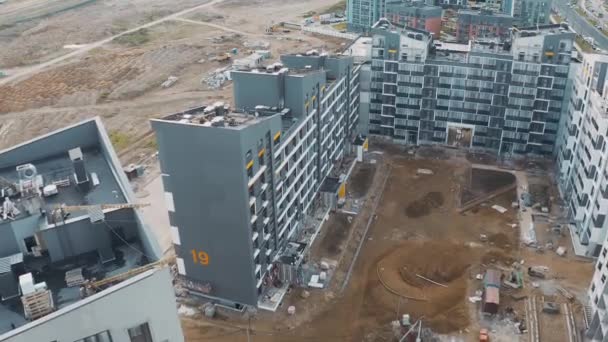 Vue aérienne du chantier de construction, processus de construction moderne une maison de panneau d'appartement. Revêtement et décoration de façades bloc d'appartements. Toits en pente avec échafaudage et cour avec vue sur le sable — Video