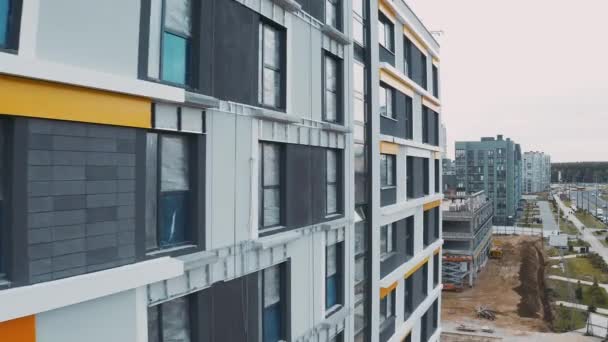 Byggarbetsplats, byggnadsarbete process moderna en lägenhet panel hus på stadens gata. Ofärdig struktur stadskärna av lägenheter. Flygfoto av fasad med fönster, tak och väg — Stockvideo