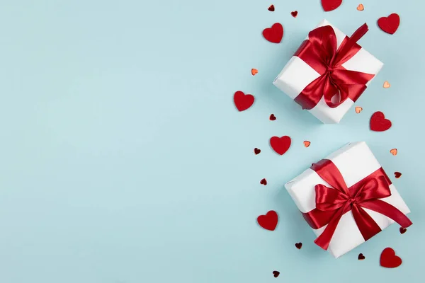 Día de San Valentín, boda o fondo del día de las madres. Cajas de regalo con cinta roja y corazones sobre fondo azul pastel. Concepto de vacaciones. plano, maqueta, vista superior, espacio para copiar. — Foto de Stock