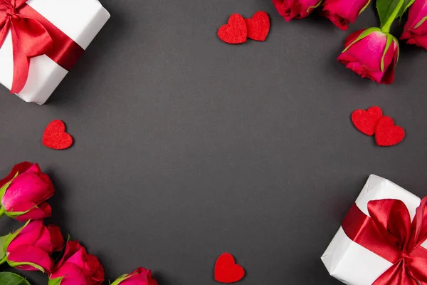 Cajas de regalo con hermosa cinta roja, corazones y rosas sobre fondo oscuro. Plano concepto laico de San Valentín, aniversario, el día de la madre y el saludo de cumpleaños. Vista superior. Copiar espacio. Burla.. — Foto de Stock