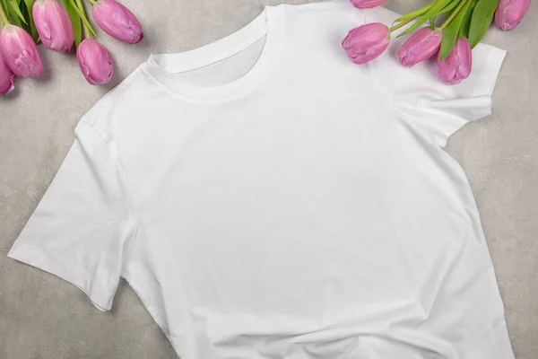白色女人的棉质T恤和粉色郁金香做了模特 设计T恤衫模板 打印演示模型 顶视图平铺 混凝土石材背景 — 图库照片
