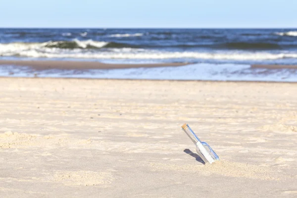 Butelka z list na plaży, płytkiej głębi ostrości. — Zdjęcie stockowe