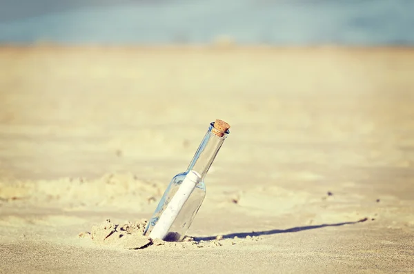 Mensagem retro tonificada em uma garrafa na praia, profundidade de campo rasa — Fotografia de Stock