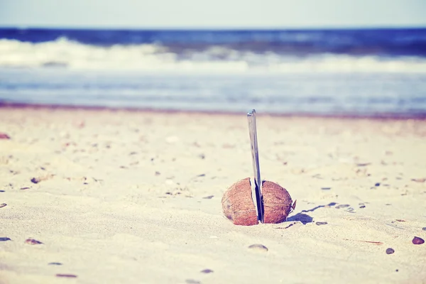 Coco tonificado vintage cortado ao meio com faca em uma praia — Fotografia de Stock