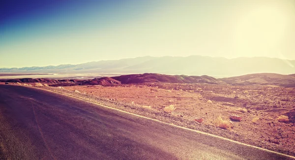 Vintage toned sunset over desert road, travel background — Stock Photo, Image