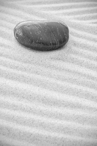 Чорно-біле зображення каменю на піску, природний фон — стокове фото