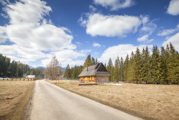 Cabaña de madera junto a un camino rural en las montañas de Tatra . —  Fotos de Stock