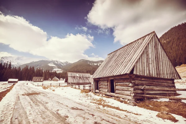 Alte filmretro stilisierte Holzhütte an einer Straße in der Tatra. — Stockfoto