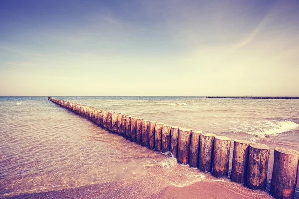 Vintage getönten hölzernen Wellenbrecher an einem Strand — Stockfoto