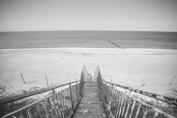 Black and white photo of wooden stairs on beach. — Stock Photo, Image