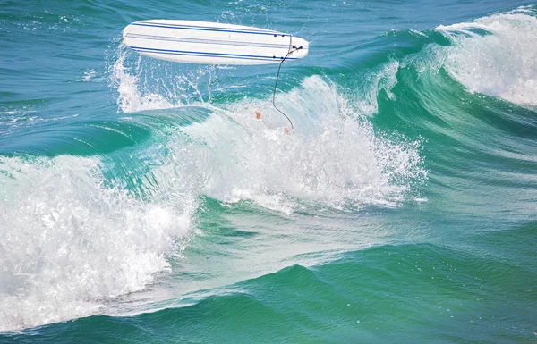 Surfista pernas na água e prancha de surf no ar . — Fotografia de Stock