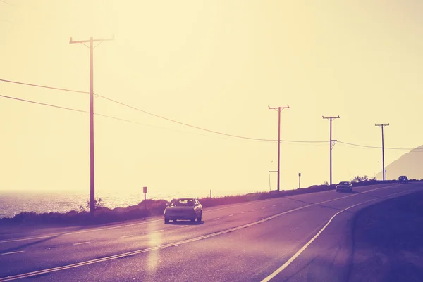 Vintage tonda ocean road karşı parlama efektli güneş. — Stok fotoğraf