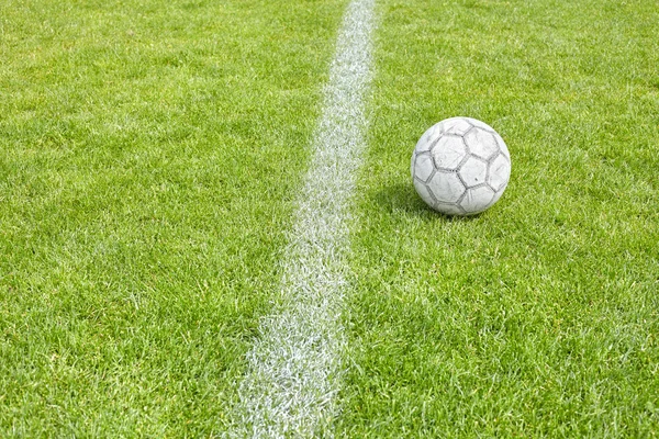 Gebrauchter Fußball auf Rasen an der Seitenlinie. — Stockfoto