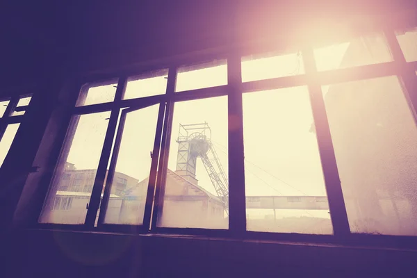 Vintage toned coal mine pithead seen through windows. — Stock Photo, Image