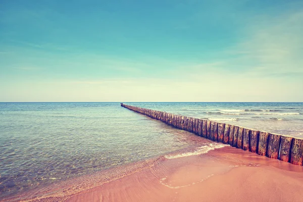 Playa retro tonificada con rompeolas de madera vieja —  Fotos de Stock