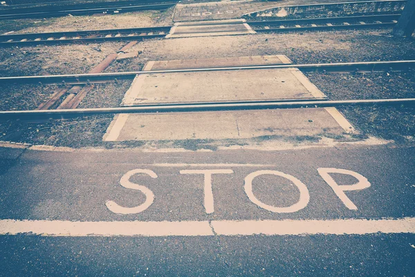 Stop sign painted in front of railroad tracks. — Stock Photo, Image