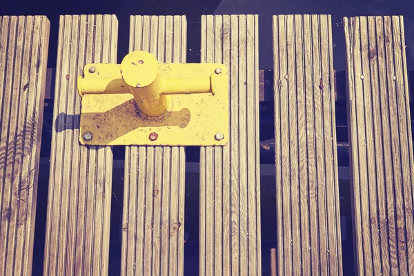 Bollard de amarração amarelo no cais de madeira . — Fotografia de Stock