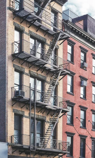 Old tenement house building with fire escape, color toned picture, New York City, USA.