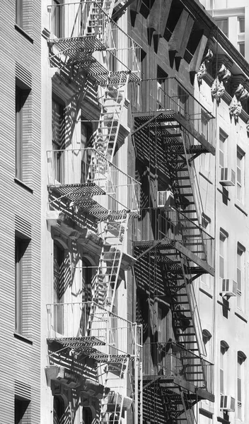Black and white picture of buildings with fire escapes, New York City, USA.