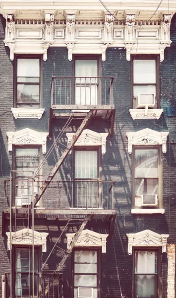 New York old townhouse with fire escape, color toning applied, USA.