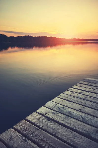夕阳笼罩在平静的湖面上 木制码头在前景中 色彩柔和 — 图库照片