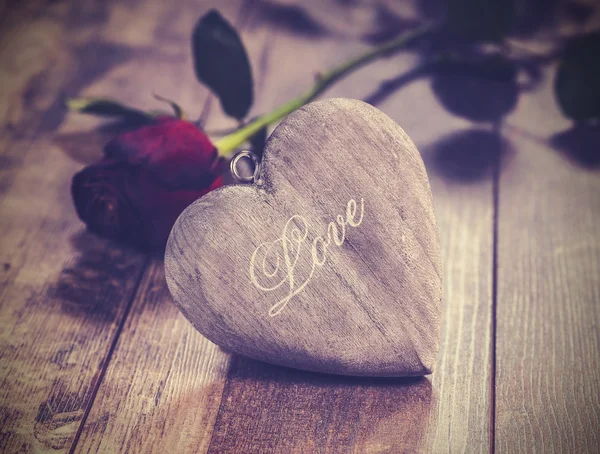 Imagen vintage del corazón sobre un fondo de madera con rosa roja . — Foto de Stock