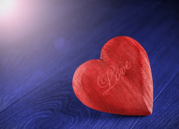 Cuore di legno rosso su sfondo blu . — Foto Stock