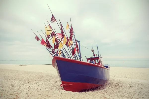 Fiskebåt på stranden, vintage retro filtreras. — Stockfoto