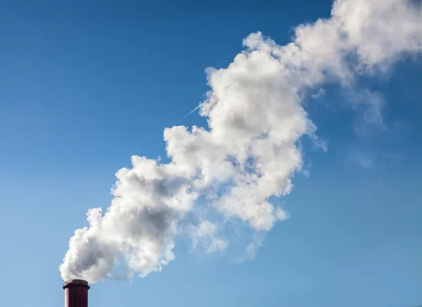 Smoke from industrial smokestack on a clear blue sky. — Stock Photo, Image