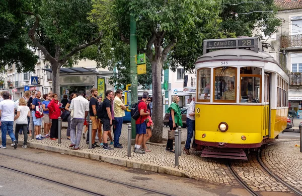 People waiting at the tram stop. Tram is the symbol of the city. — Stock Photo, Image
