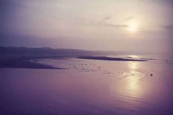 Vintage gefiltertes Bild vom Strand bei Sonnenuntergang. — Stockfoto