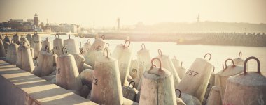 Retro filtered photo of concrete block breakwater. clipart