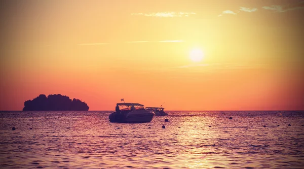 Vintage gefilterte Silhouette einer kleinen Insel und eines kleinen Bootes bei — Stockfoto