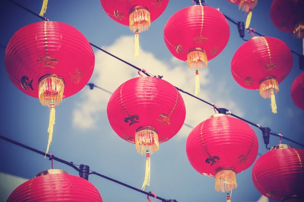 Linternas de papel rojo chino filtradas retro contra el cielo azul . —  Fotos de Stock