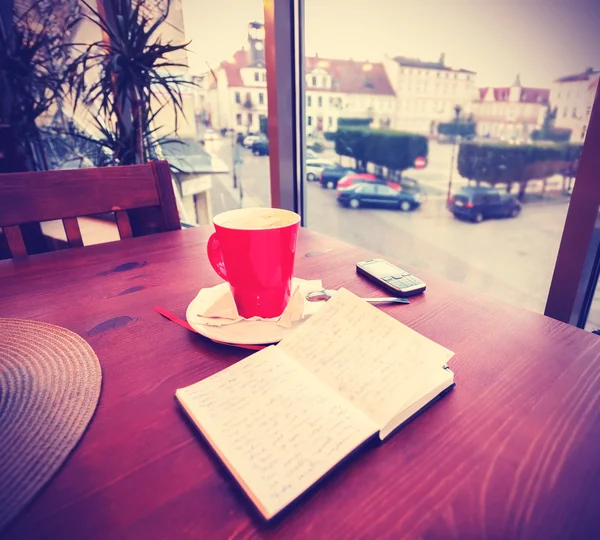 Vintage-Instagram wie getönte Kaffeetasse und Tagebuch im Coffeeshop — Stockfoto