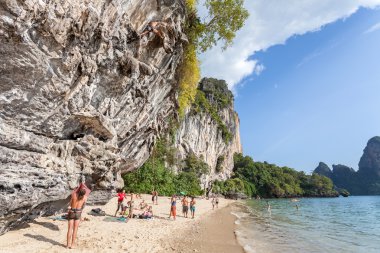 Rock climbers and tourists on Railay beach. clipart