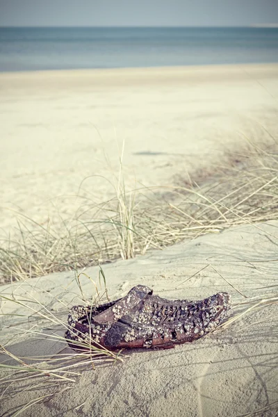 Ретро-фильтрованная обувь вымыта на пляже . — стоковое фото