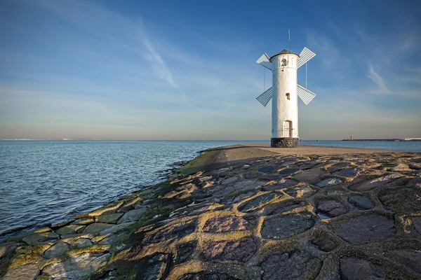 Wschód słońca na wybrzeżu, latarni morskiej wiatrak w Świnoujście, Polska — Zdjęcie stockowe
