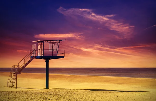 Torre de salvavidas en una playa al atardecer . — Foto de Stock